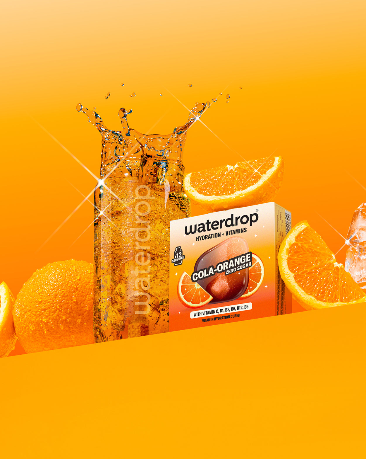 COLA ORANGE Duopakket: Een glas bruisend water met een waterdrop® kubus, naast een doos Cola-Orange hydratieblokjes (12 porties) met vitamines. Sinaasappels en ijsblokjes omringen de presentatie.