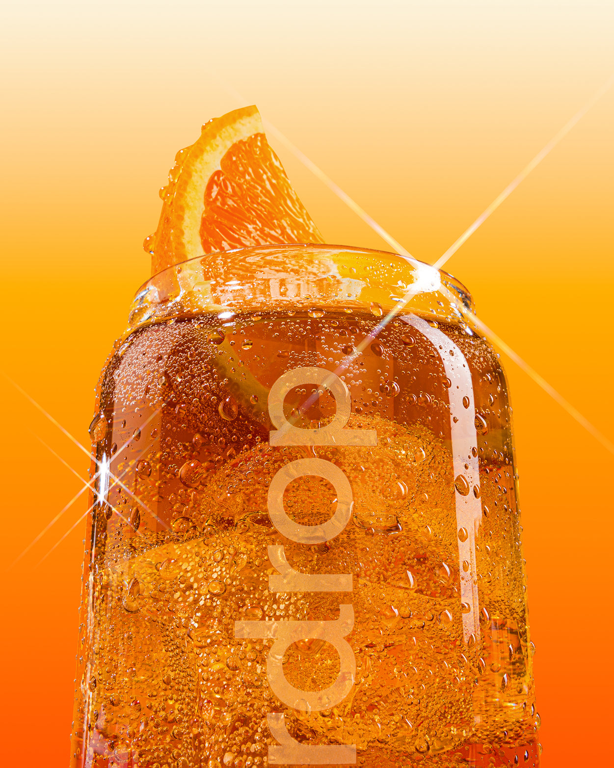 Een close-up van een COLA glazen blikjesset gevuld met een bruisende, oranje drank. Condensdruppels sieren het glas met een sinaasappelschijf op de rand, omgeven door een sprankelende achtergrond.