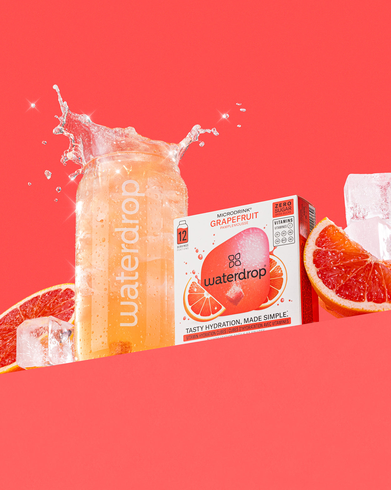 Frisdrankenset: Een heldere waterdrop-glas met sprankelende grapefruitdrank, omringd door een doos waterdrop Microdrink Grapefruit en verse grapefruithalven. Suikervrije verfrissing met toegevoegde vitaminen.