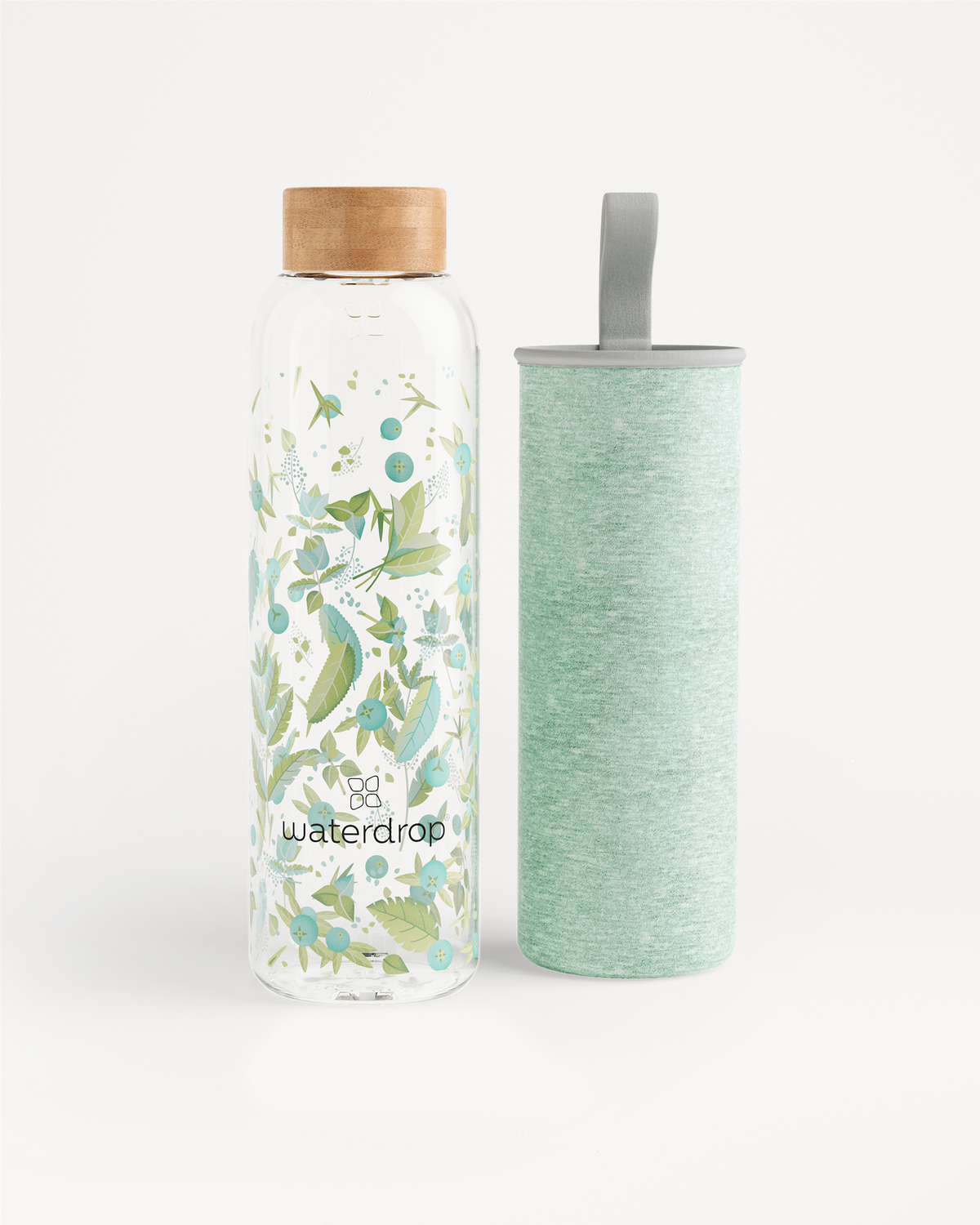 Edition Glass van robuust borosilicaatglas, cilindervorm voor thuisgebruik. Close-up toont detail van het textielpatroon en een patch, ideaal voor duurzaam water drinken onderweg. Beschikbaar in 600 ml en 1L.