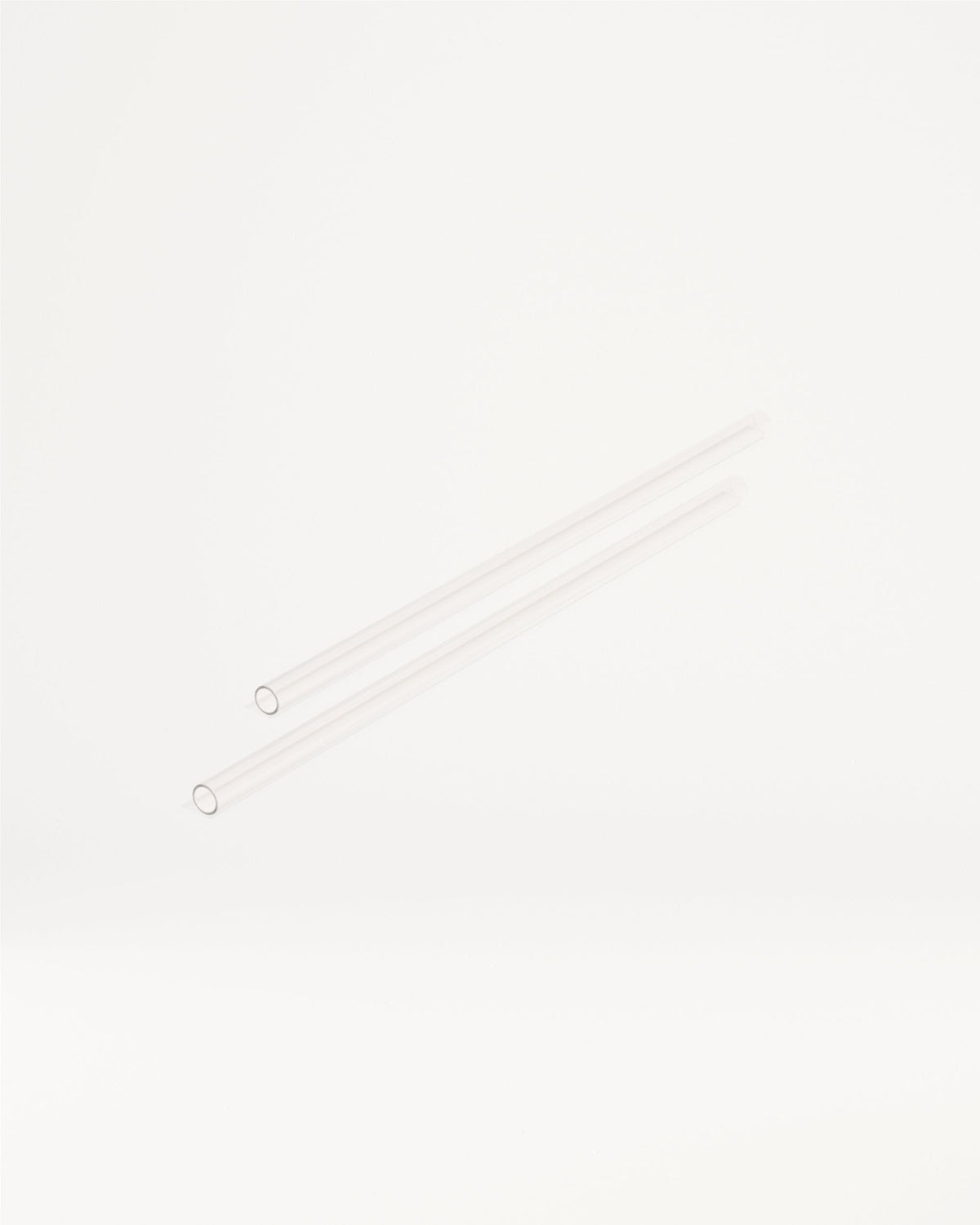 Twee lange, slanke, transparante buisjes, vergelijkbaar met glazen of plastic rietjes, liggen diagonaal. Dit zijn de Explorer Thermo Tumbler Straws, perfect voor waterdrop®'s innovatieve drinkproducten.
