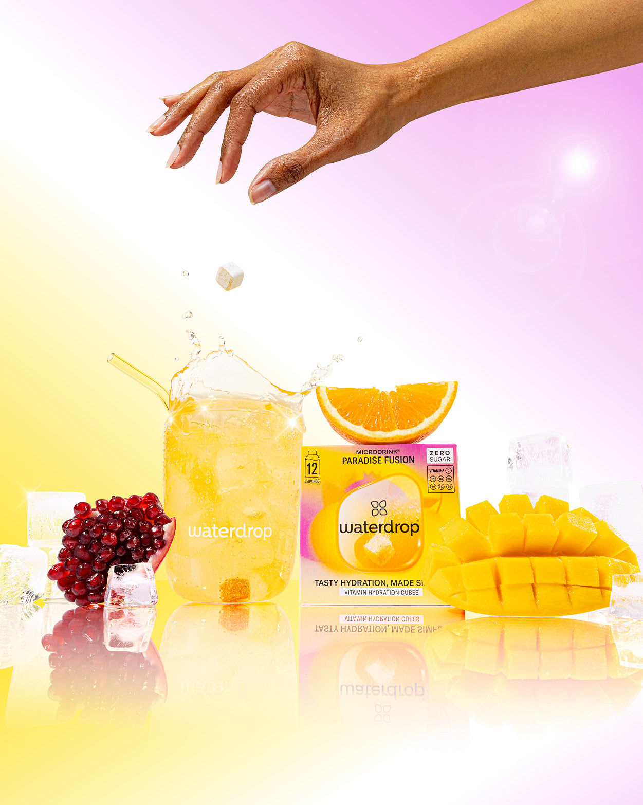 PARADISE FUSION: Een verfrissende mix van sinaasappel en mango, afgebeeld met een pomegranate en ijsblokjes, perfect voor een zomerse dorstlesser van waterdrop® NL.