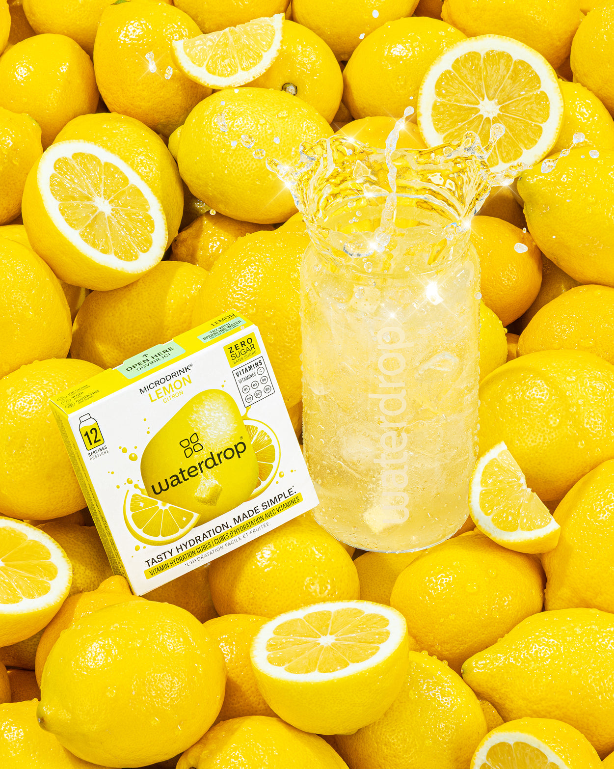 Prikkelend Trio Set: Een levendige presentatie van waterdrop Microdrink Lemon, met een doosje en een waterfles gevuld met ijskoud citroenwater, omringd door verse citroenen. Geniet van bruisende smaken!