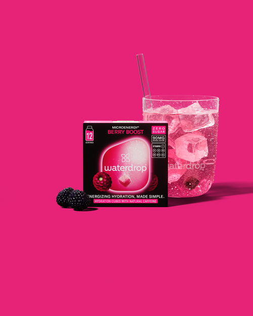 BERRY BOOST energiedrank met braamsmaak en ijsblokjes in een glas, verrijkt met kolanoot voor natuurlijke cafeïne. Een verfrissende keuze voor een directe energieboost.