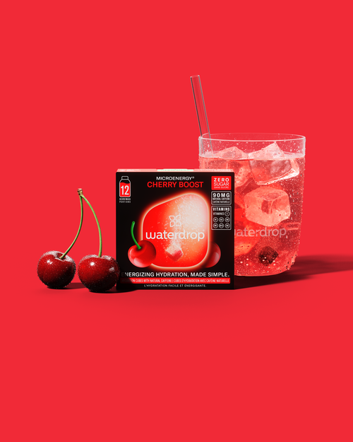 CHERRY BOOST energiedrank met guarana en kersensmaak, suikervrij, verfrissend en zuur zoals kersensnoepjes. Close-up van een kers benadrukt de fruitige essentie van deze waterdrop® drank.