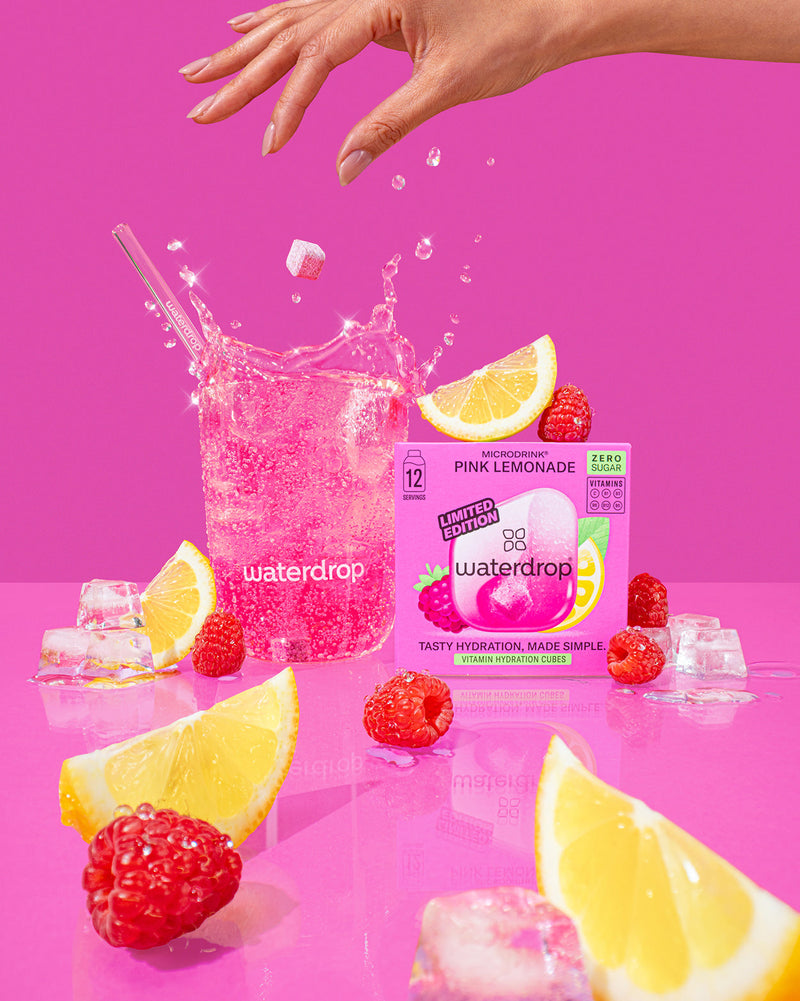 PINK LEMONADE: Een hand houdt een fles met de smaakvolle combinatie van frambozen en citroen, een tijdelijke offer van waterdrop® NL, perfect voor een verfrissende, suiker- en calorievrije dorstlesser.