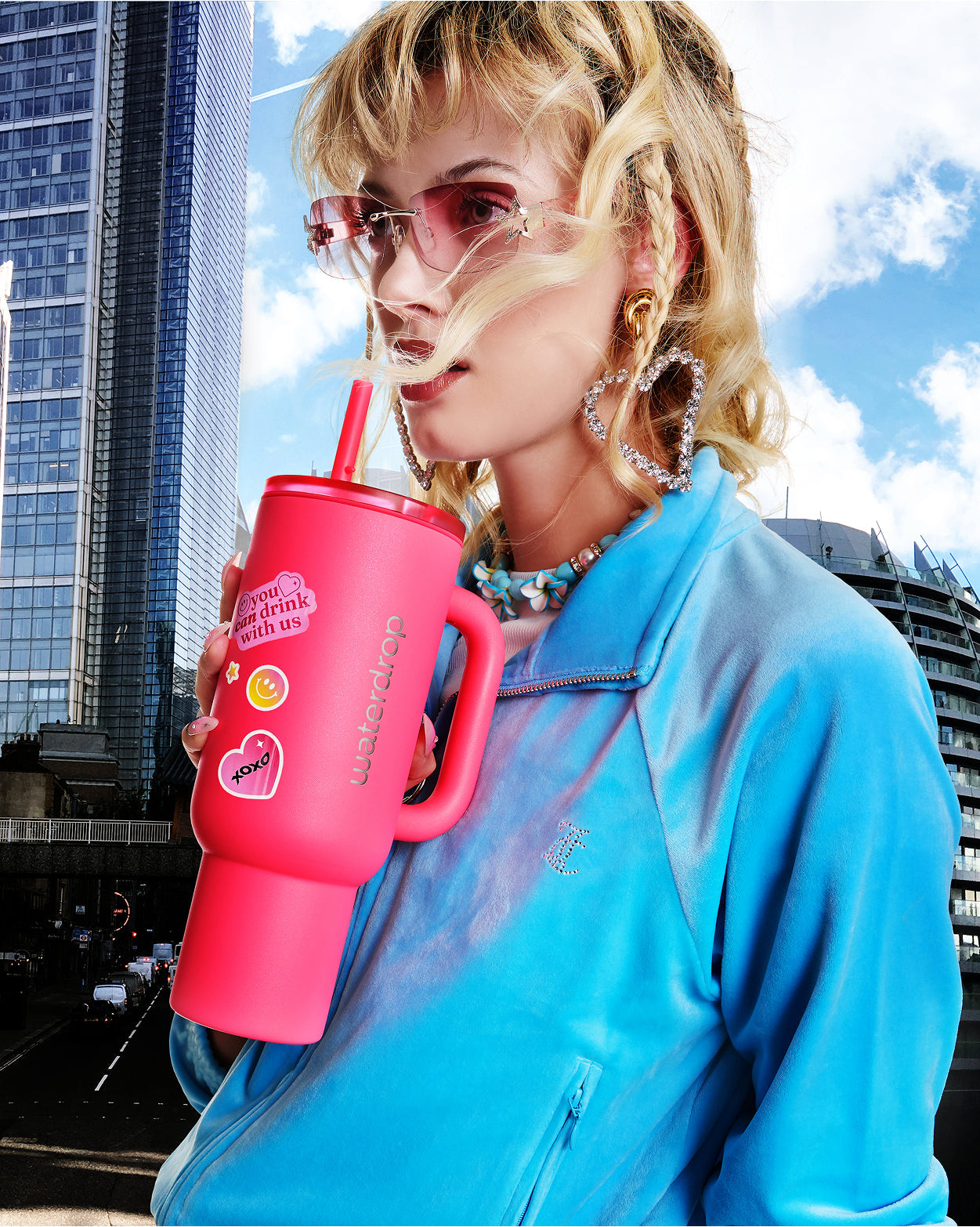 Een persoon houdt de Neonroze Explorer Thermo Drinkbeker vast, met dubbelwandige isolatie en een openklapbaar rietje, ideaal voor hydratatie. De Limited Edition neonroze kleur maakt deze beker extra opvallend.