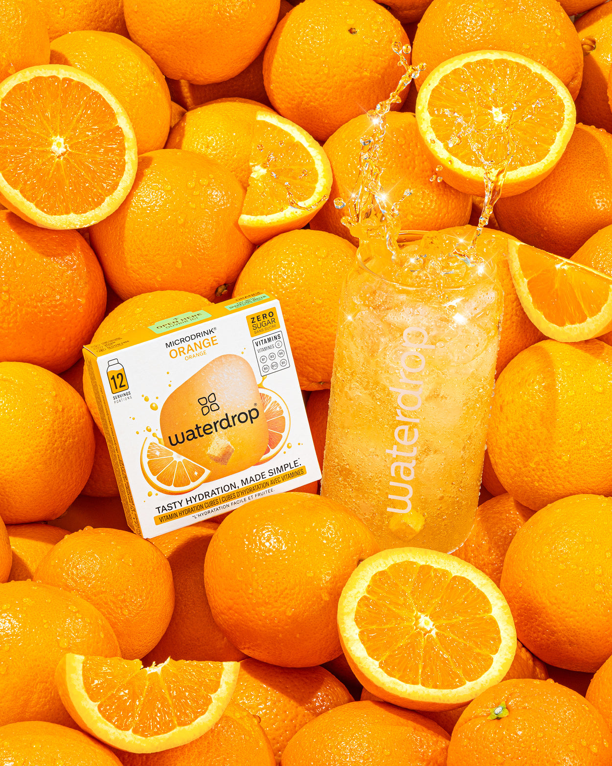 Prikkelend Trio Set: Een arrangement van hele en halve sinaasappels met een doos waterdrop Microdrink Orange cubes en een glas bruisend, sinaasappel-geïnfuseerd water. Inclusief smaken sinaasappel, cola en limoen-citroen.