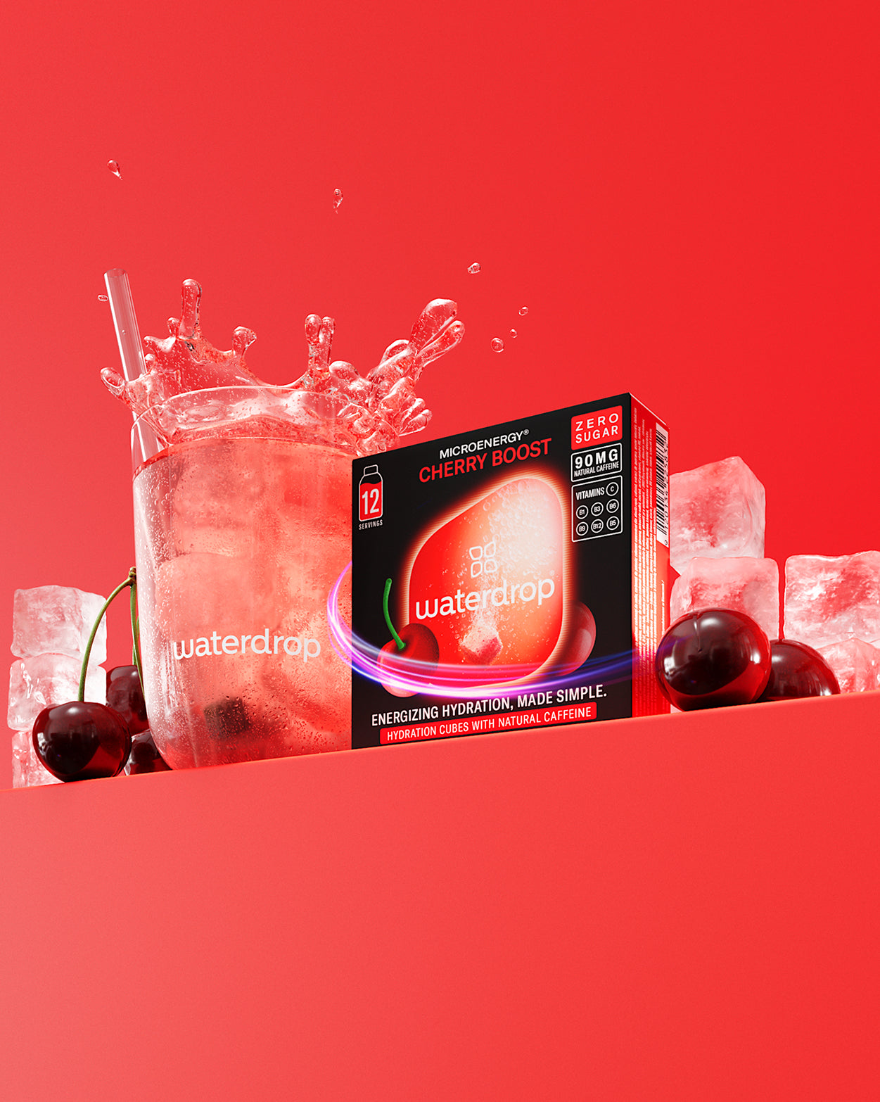 Glazen set Booster: Een helder glas met een rode drank en ijs, omringd door een doos waterdrop Microenergy® Cherry Boost, verse kersen en ijsblokjes, tegen een rode achtergrond.