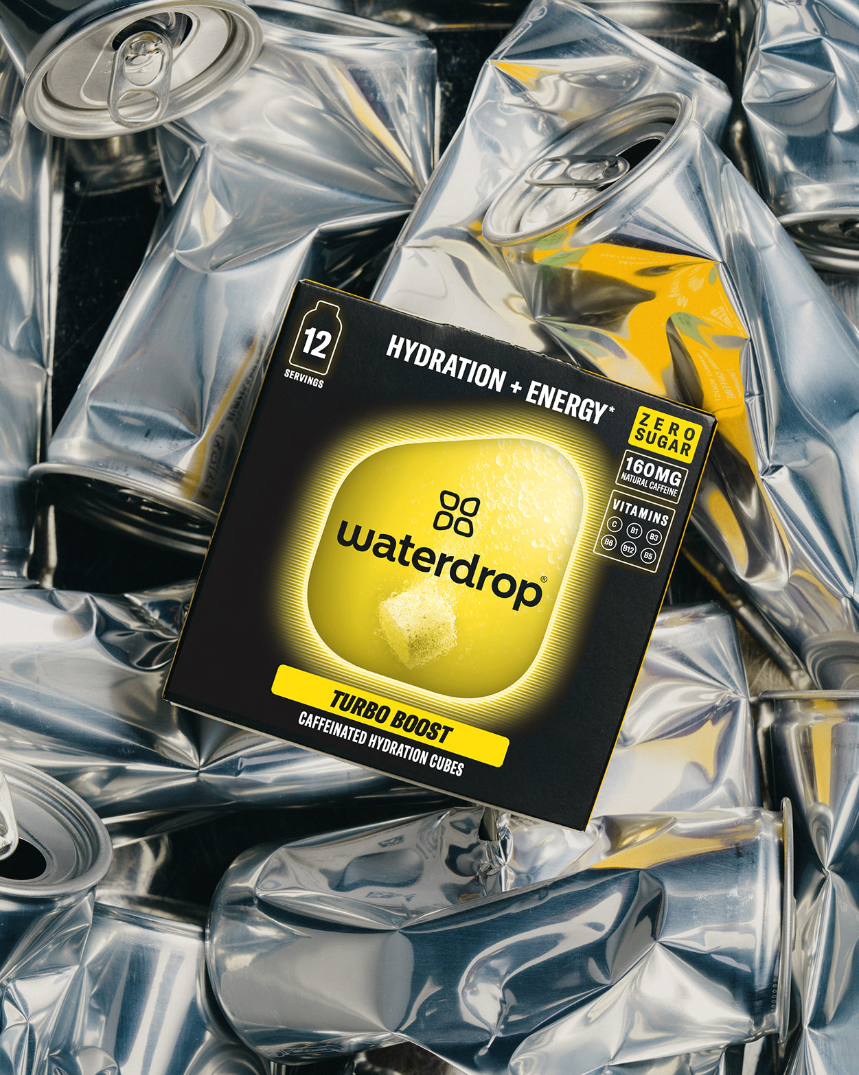 TURBO BOOST duopakket van waterdrop®: Caffeïnehydratering in een zwart-gele doos met 24 blokjes, 160 mg natuurlijke cafeïne per portie, rustend op geplette blikjes. Perfect voor energie zonder suiker.