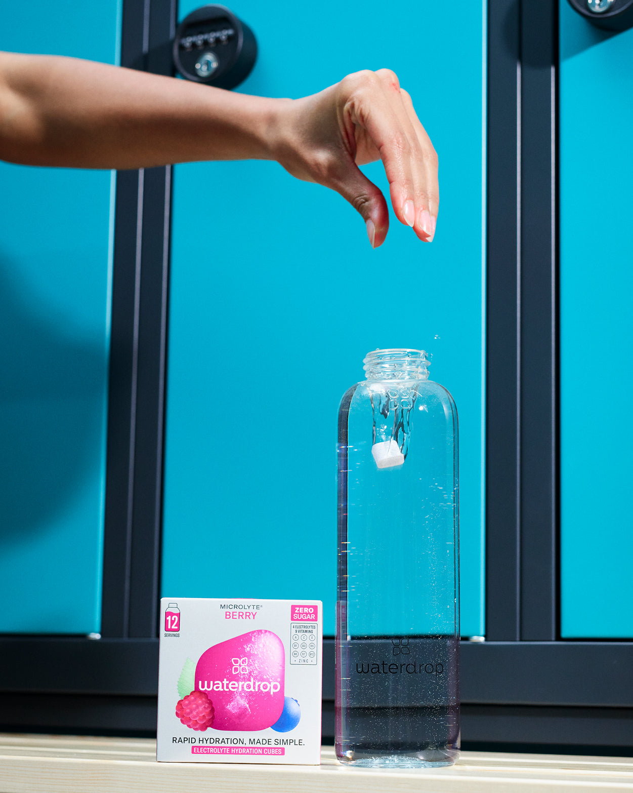 Hydratatieset Turbo: een Waterdrop‐fles met water, een Microlyte‐blokje in beweging, en een doos 'Berry' smaak. Deze set bevordert snelle hydratatie met 12 suikervrije blokjes voor optimale prestaties.