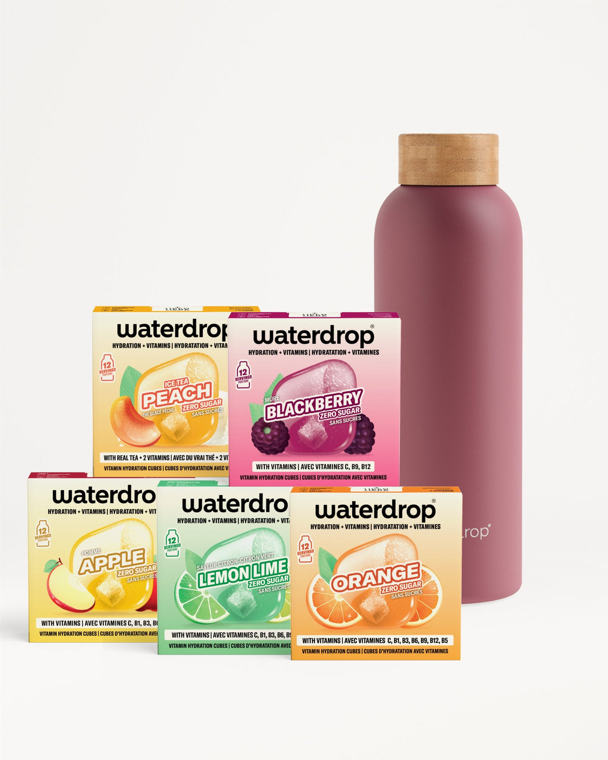 Productdisplay van de 30 Days Starter Set Thermo Steel met waterdrop® hydraterende kubussen. Vijf smaakdozen (Ice Tea Peach, Blackberry, Apple, Lemon-Lime, Orange) naast een waterdrop fles met houten look dop.