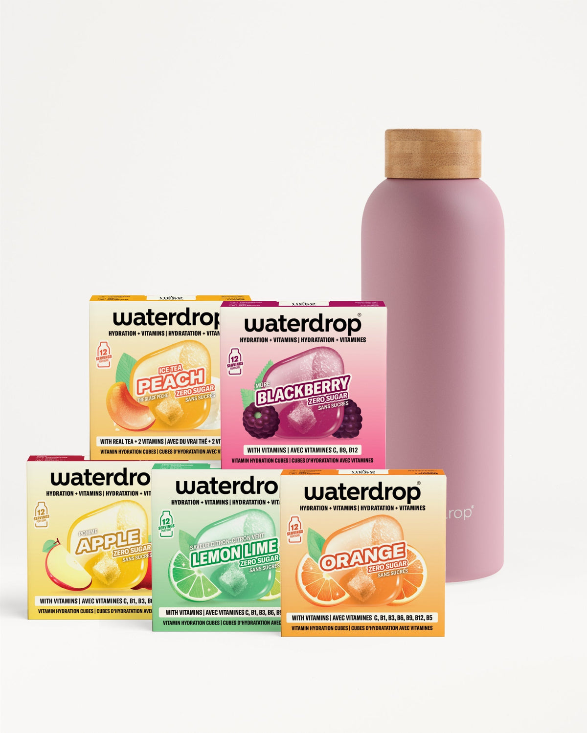 Vijf dozen Waterdrop vitamin hydration cubes in smaken Perzik Ijsthee, Braam, Appel, Citroen-Limoen en Sinaasappel, vormen een piramide. Achter hen staat een roze thermosfles met houten dop, de 30 Dagen Starter Set Thermo Steel.