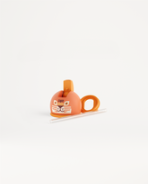 Dop met rietje voor Peuterfles, ontworpen voor kleine handjes, met opklapbare rietjesopening voor lekvrij drinken; te zien naast een tape dispenser met cartoon tijgergezicht en buis met beker.