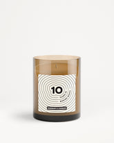 Bruine glazen kaars in pot met wit label en ontwerp met concentrische cirkels.