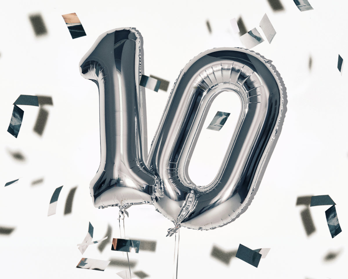 Zilveren folieballonnen in de vorm van het getal 10 met verspreid confetti.