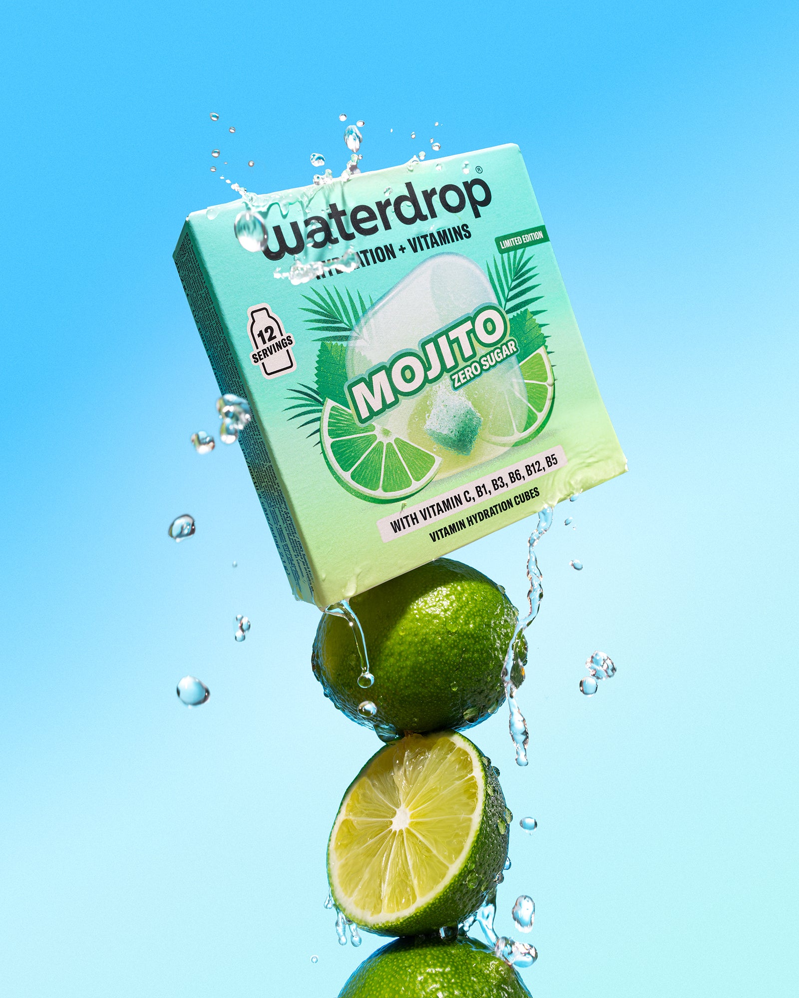 Limoenen gestapeld onder een mintgroene drankdoos met waterschapsijs tegen een blauwe achtergrond.