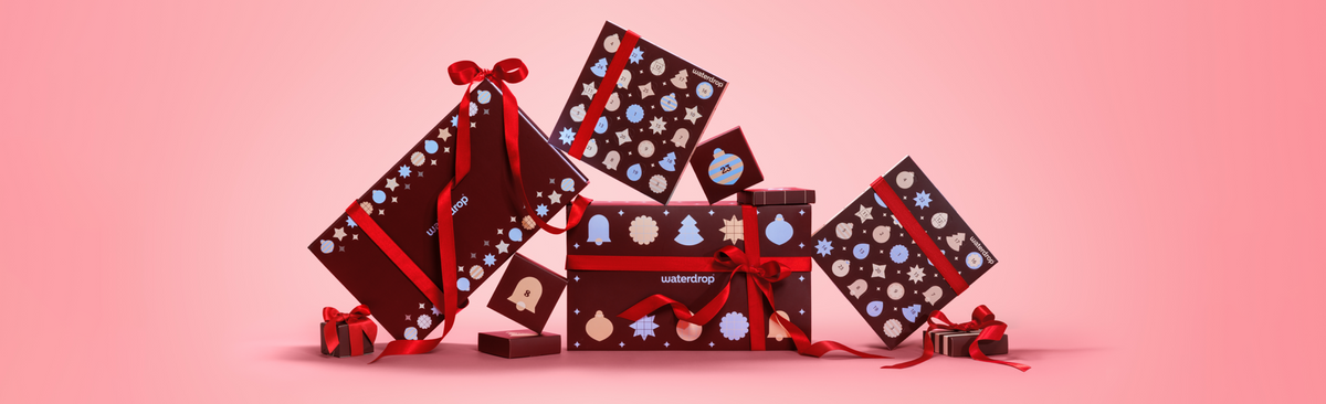 Kleurrijke cadeauverpakkingen op een feestelijke voorstelling tegen een roze achtergrond met verloop.