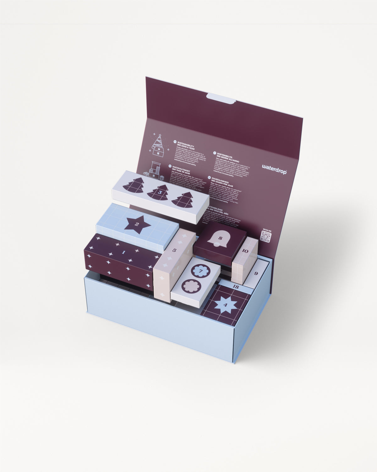 Drievoudige lichtblauwe geschenkdoos met paarse deksel geopend om verschillende kleine decoratieve doosjes in bijpassende kleuren te onthullen.