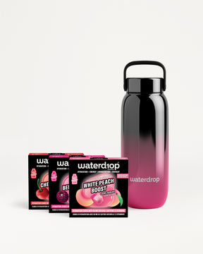 Herbruikbare waterfles met zwart-roze kleurverloop en verschillende smaakzakjes.