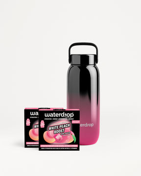 Herbruikbare waterfles met verloop van zwart naar roze naast twee Waterdrop-verpakkingen.
