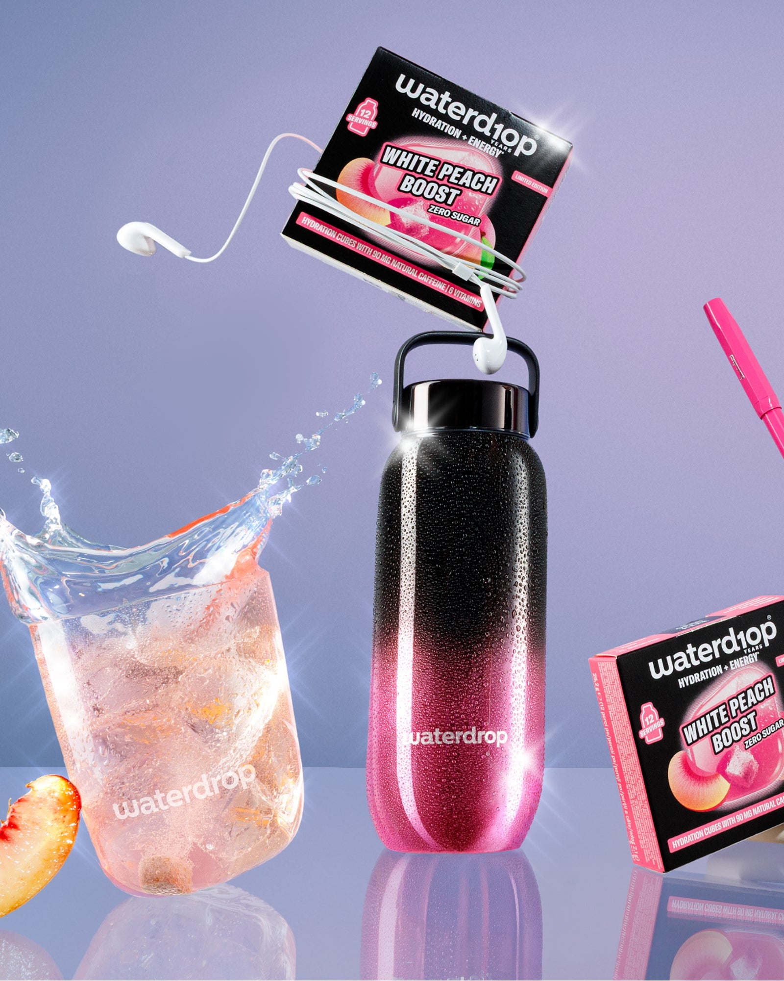 Herbruikbare fles met roze-naar-zwart verloop en lusgreep, gekoppelde smaakzakjes, glas ijs met perzikpartje en roze rietjesaccessoire.