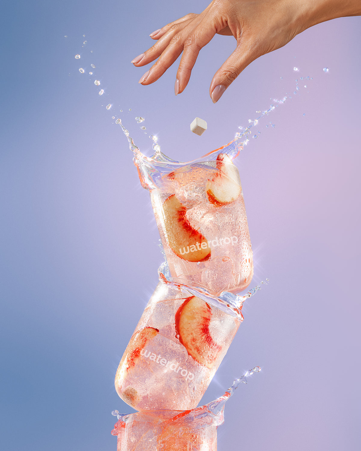 Opgestapelde ijsblokjes met aardbeienschijfjes en een hand die een blokje laat vallen, met waterschieters.