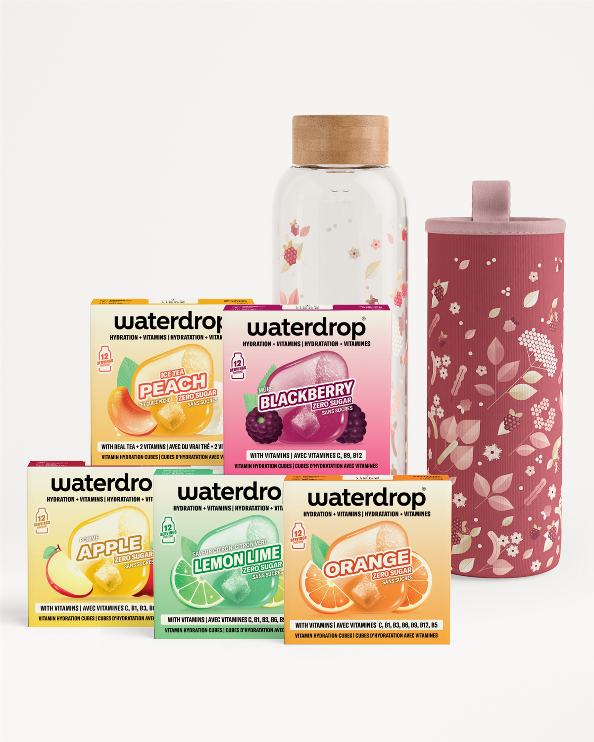 Gevarieerde Waterdrop-smakende doosjes, een heldere fles met kurk en een roze bloemetjes geïsoleerde tumbler.