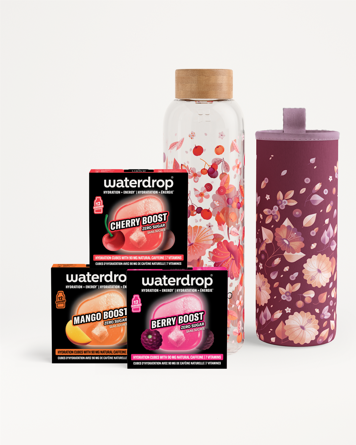 Set met smaakboosters in doosjes naast een glazen fles en een bloemenpatroon beker.