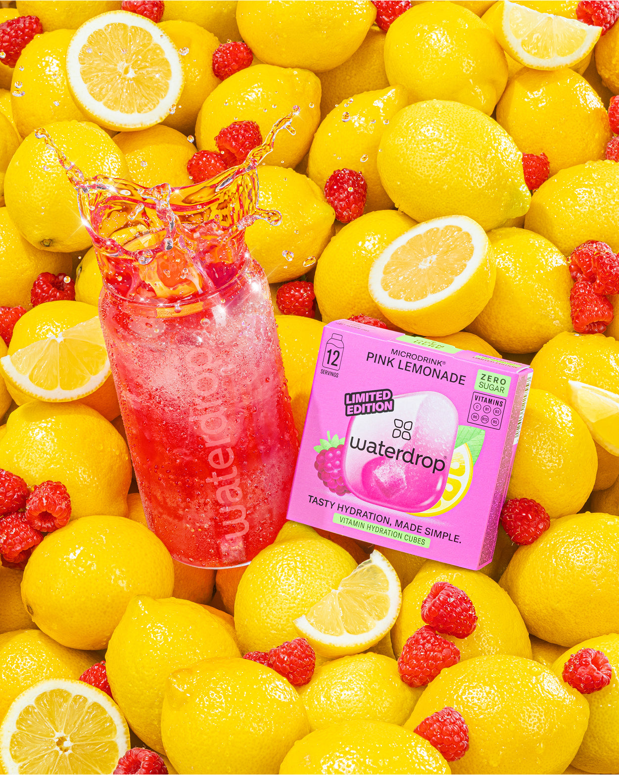 Roze limonade fles en Waterdrop-doos tussen gele citroenen.