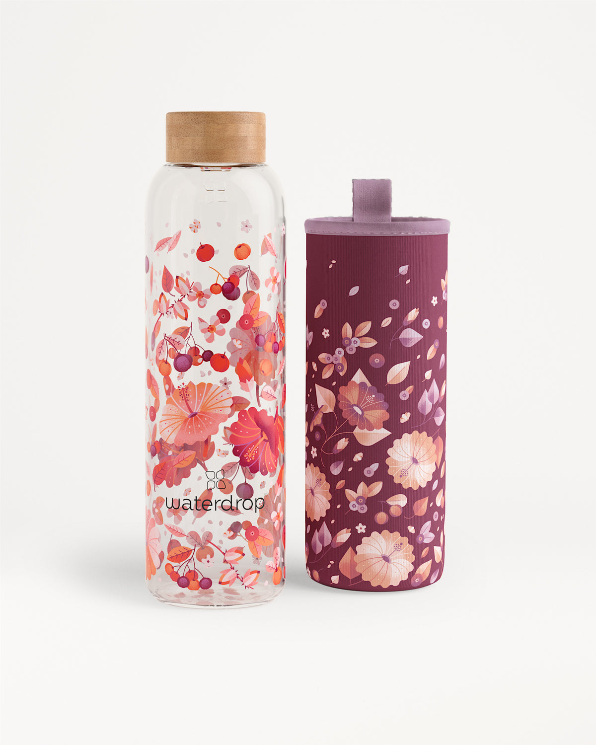 Twee flesjes water met een bloemendessin, een heldere fles met houten dop en een paarse fles met een bloemige hoes.