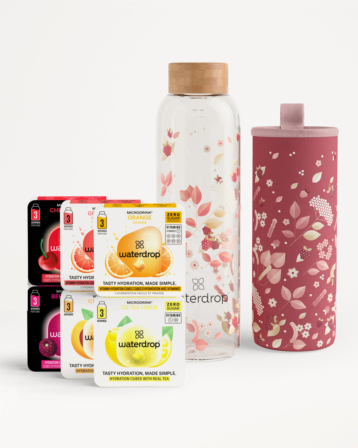 Verschillende Waterdrop-drankmixen sachets met een glazen fles met houten dop en een roze thermische hoes met bloemen.