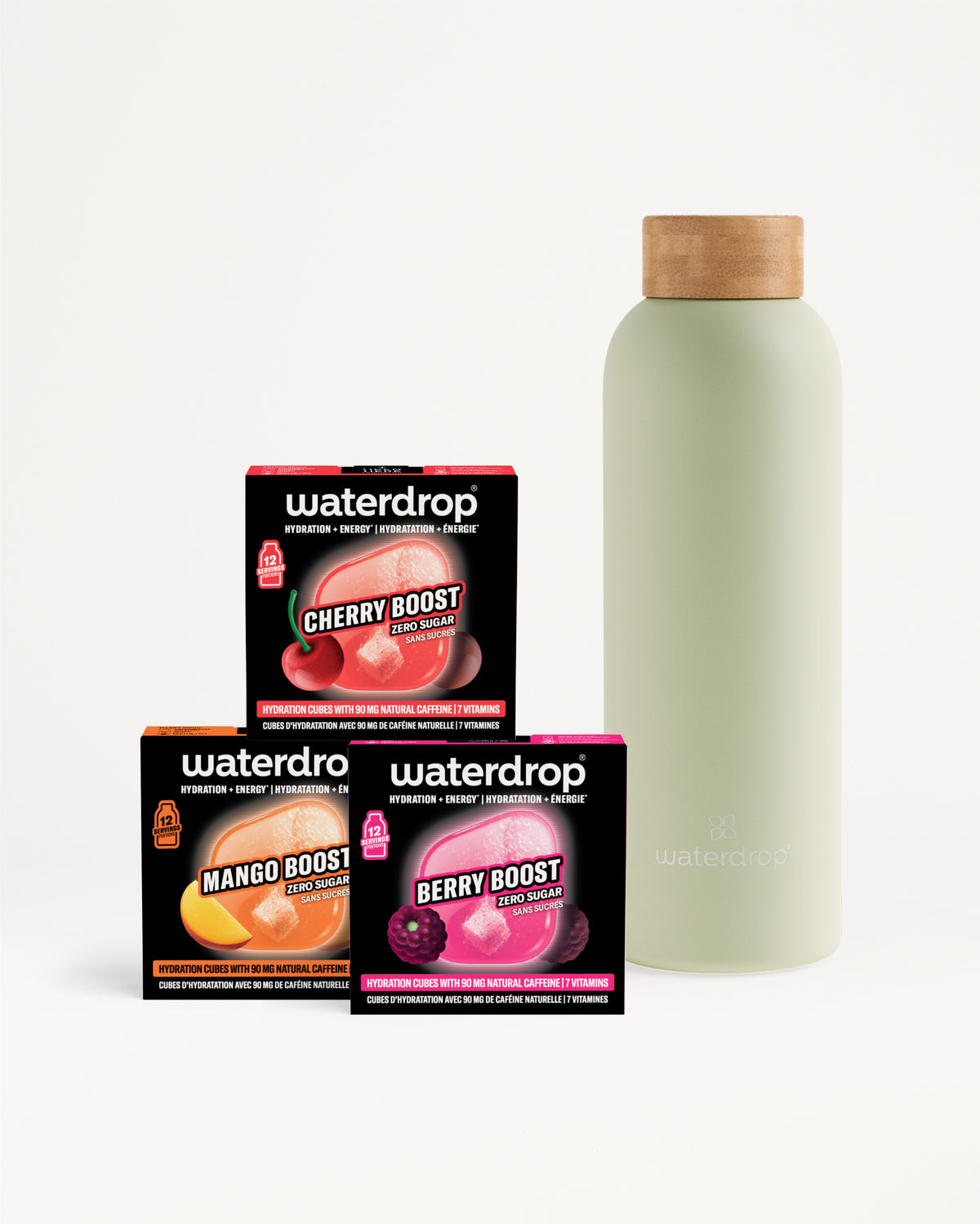 Drie Waterdrop boosterdoosjes (Cherry, Mango, Berry) naast een lichtgroene fles met houten dop.