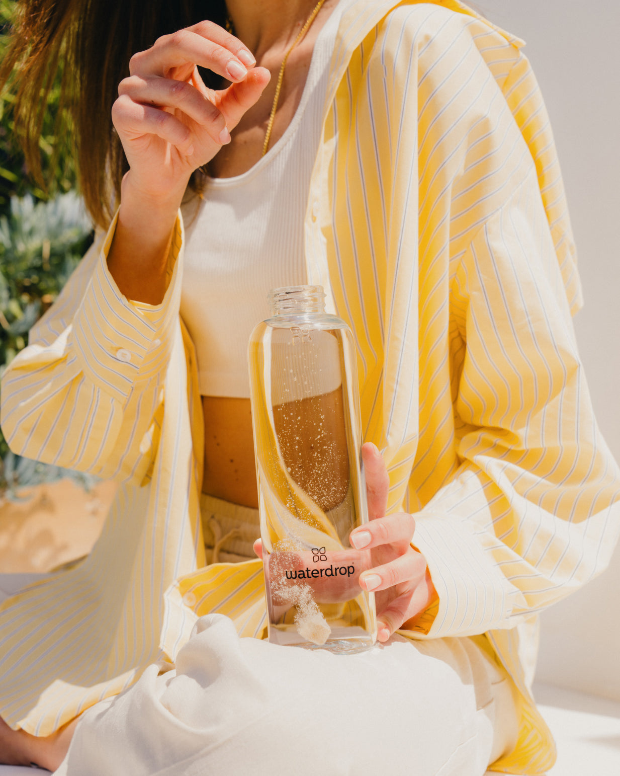 Persoon demonstreert de Mix Taster Pack van waterdrop®, met een bruisend tablet dat in een flesje oplost, om water op smaak te brengen met natuurlijke fruit- en plantenextracten.