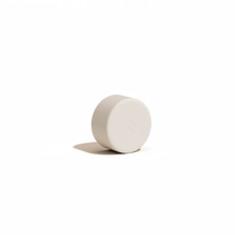 RVS flessendop met een matte afwerking en subtiel vierbladig reliëf, passend voor zowel glazen als roestvrijstalen flessen, ligt op zijn zijde tegen een zachte achtergrond.