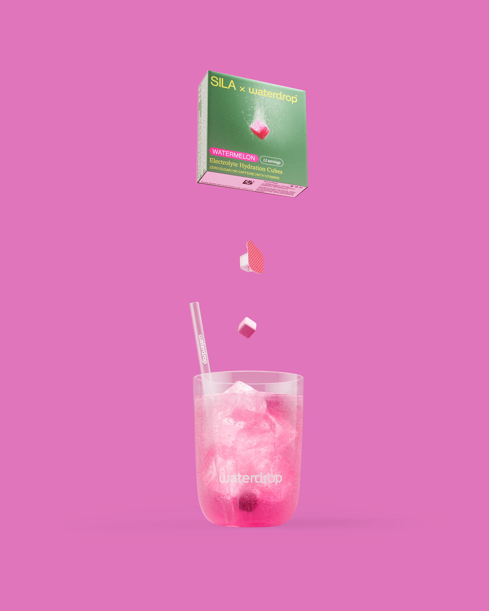 SILA Watermelon elektrolytenhydratiekubussen zweven boven een glas roze drank met ijs, met een rietje. Verpakt in een groene en roze doos, zonder suiker of cafeïne, verrijkt met vitamines.